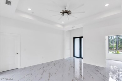 Spare room featuring marble finish floor, a tray c