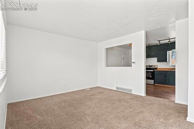 Unfurnished living room featuring carpet floors and rail lighting