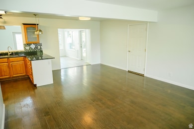 Kitchen featuring glass insert cabinets, tasteful backsplash, healthy amount of natural light, and dark wood finished floors