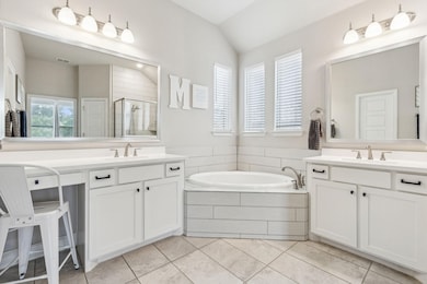 Bathroom featuring lofted ceiling, separate shower and tub, tile patterned floors, and vanity