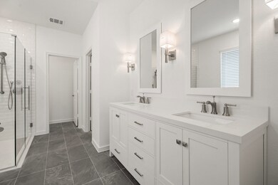 Primary bath features freestanding vanity with dual sinks