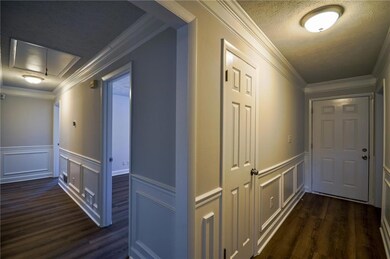 Corridor with crown molding, dark hardwood / wood-