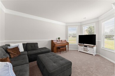 Living room featuring crown molding and carpet flooring
