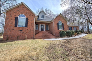View of front of house with a front yard, brick siding, and a shingled roof