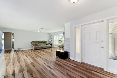 Entrance foyer with ceiling fan and light hardwood