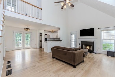 Living area with a ceiling fan, high vaulted ceili