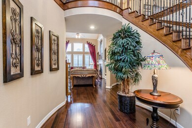 Once you step through the doorway, you will instantly feel the warmth of this great floorplan with its gorgeous, curved staircase and rich hardwood floors.  The wall of windows ahead, look out to the pool.