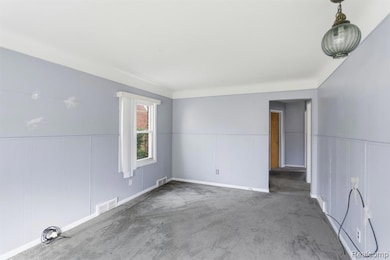 Carpeted empty room with wainscoting and a decorative wall