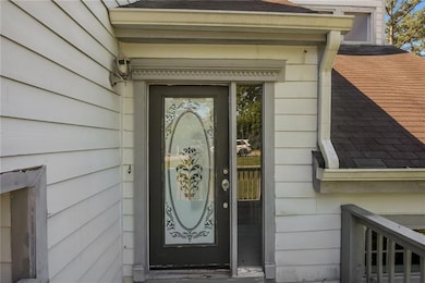 Property entrance featuring a shingled roof