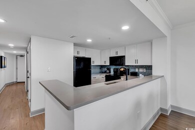 Kitchen with crown molding, a sink, light wood fin