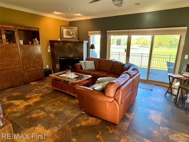 Living room featuring ornamental molding and a fireplace