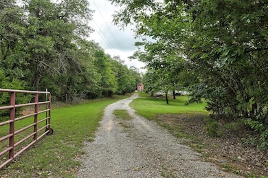 View of dirt / gravel road featuring a gated entry