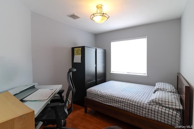 Bedroom featuring dark wood-style flooring and a desk