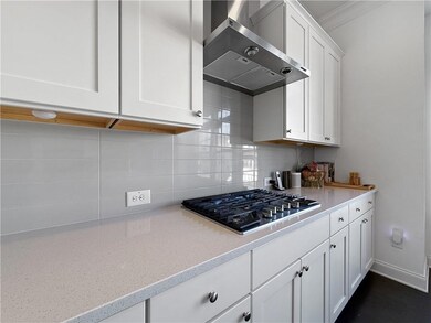 Kitchen featuring wall chimney range hood, stainle