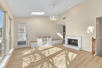 Living room with a skylight, a brick fireplace, hi