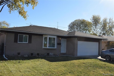 Ranch-style house with brick siding, roof with shingles, a front yard, an attached garage, and crawl space