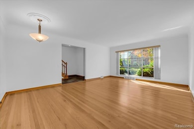 Spare room with light wood-style flooring and stairs