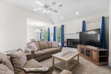 Living room with ceiling fan with notable chandeli