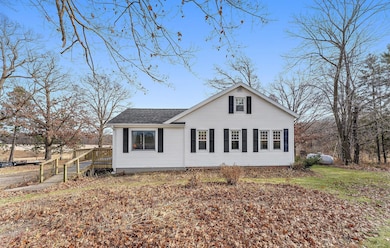 The front of the house features ramp access up onto the deck and front door. The home is surrounded by light tree coverage.