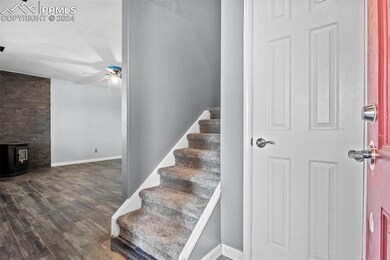 Stairs featuring ceiling fan, a wood stove, and da