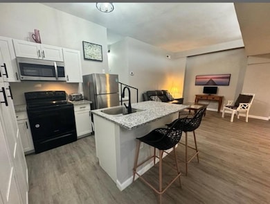 Kitchen featuring white cabinets, a sink, applian