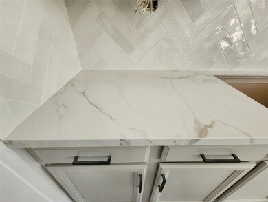 Beautiful backsplash with white quartz countertops.