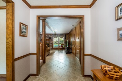 Lovely entry into the home with large tile flooring and a view to the pool the minute you come in the front door!  Wood crown moulding, wood chair rail and rich wood paneling found throughout this home.