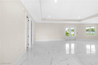 Spare room featuring french doors and a tray ceili