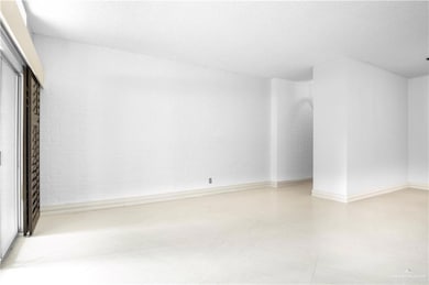 Spare room featuring a textured ceiling, baseboards, and tile patterned floors