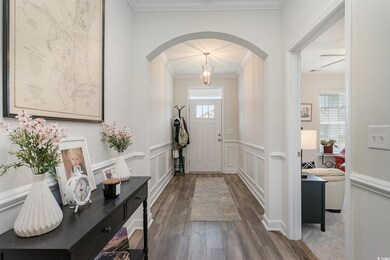 Foyer entrance featuring ornamental molding, wood-