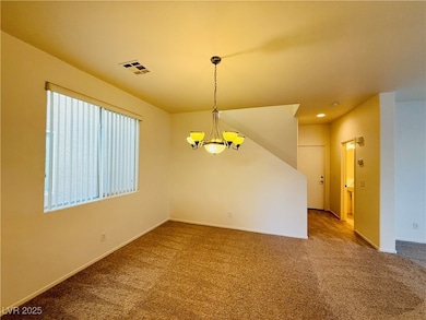 Carpeted empty room featuring a chandelier and recessed lighting