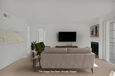 View of tiled living room with fireplace. This pic