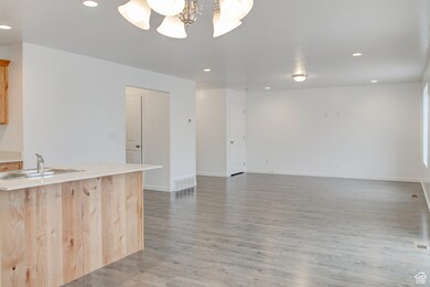 Kitchen featuring recessed lighting, light countertops, light wood-type flooring, light brown cabinetry, and open floor plan