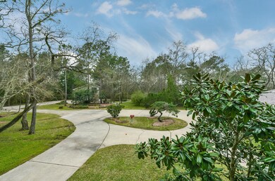 A gravel road meanders beyond the limits of Fence Post Drive, winding between sprawling trees of every variety, and then spills out onto a paved and manicured circular drive in this clearing that contains the main house as well as the 3 car detached garage and workshop.