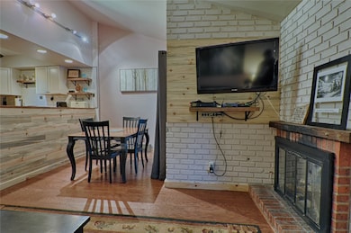 Dining area with vaulted ceiling, a brick fireplac