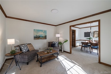 Living room with crown molding opens to dining roo