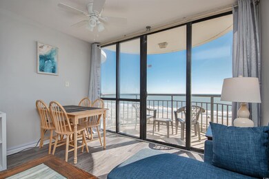 Dining room featuring floor to ceiling windows, a water view, wood finished floors, and a ceiling fan
