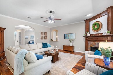 Living room with hardwood flooring, crown molding,