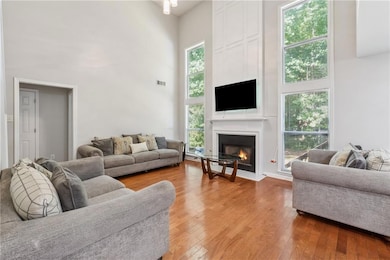 Living area featuring a high ceiling, a fireplace, and light wood-type flooring