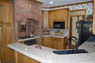Kitchen featuring sink, black appliances, and orna
