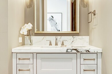 Absolutely gorgeous powder bath with a stunning Calacatta Borghini marble vanity awaits the first floor living area.