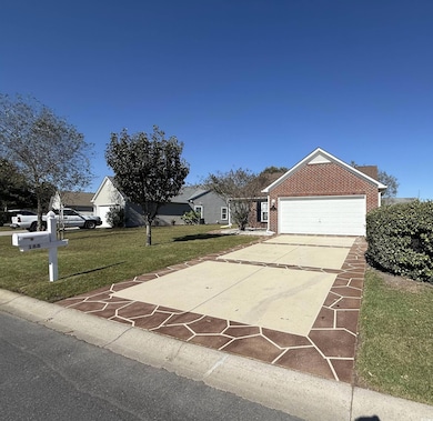 Single story home featuring a front lawn, driveway, and brick siding