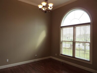 Hardwood floor and arched window in formal dining room.