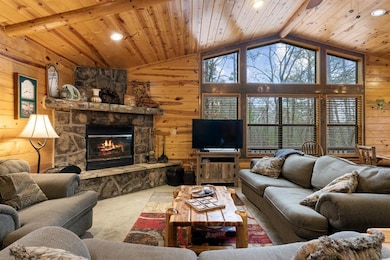 Carpeted living area with wooden ceiling, wood wal