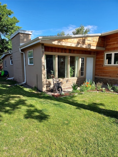 Rear view of house with a yard and a chimney