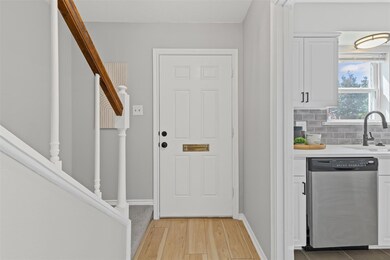 Entryway featuring a sink, baseboards, light wood 