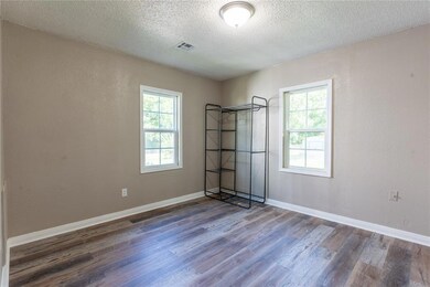 Unfurnished room featuring a textured ceiling, a w