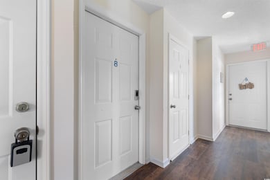 Entrance foyer featuring dark wood-style floors, baseboards, recessed lighting, and a textured ceiling