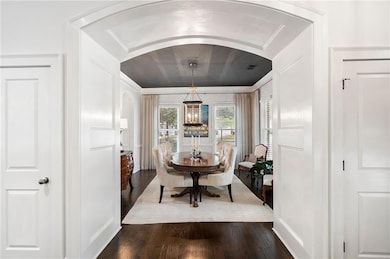 Dining space with arched walkways, dark wood finis