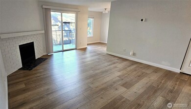 Beautifully updated with brand new luxury vinyl plank floors and fresh paint, this inviting living room offers generous space and a classic wood-burning fireplace.